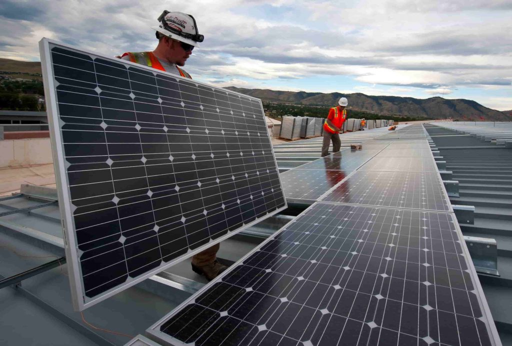 Ouvriers Nextensia installant un bâtiment neuf avec panneaux photovoltaïques